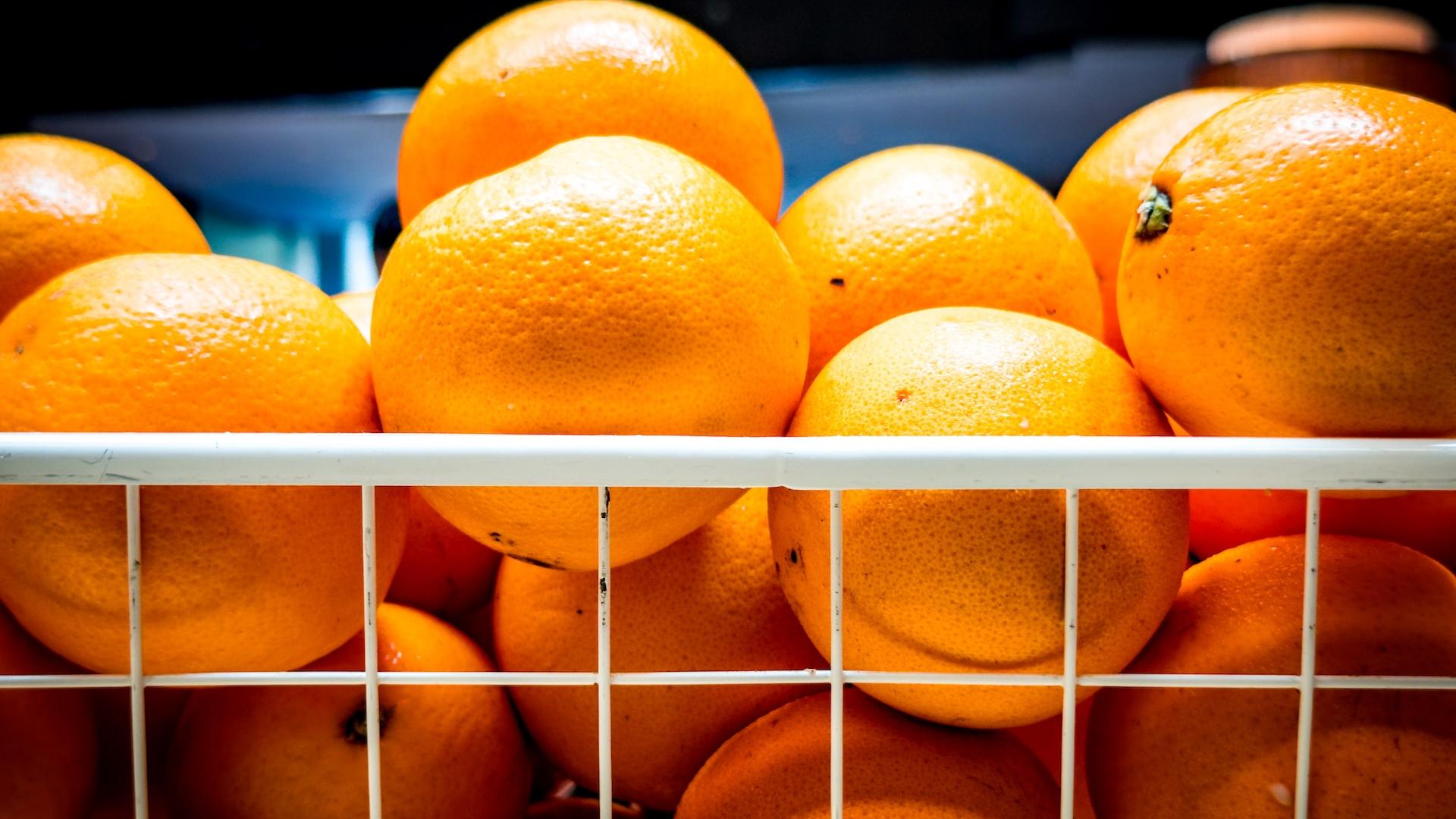 a bunch of oranges are stacked in a basket